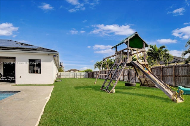 view of yard featuring a patio area, a fenced backyard, and a playground