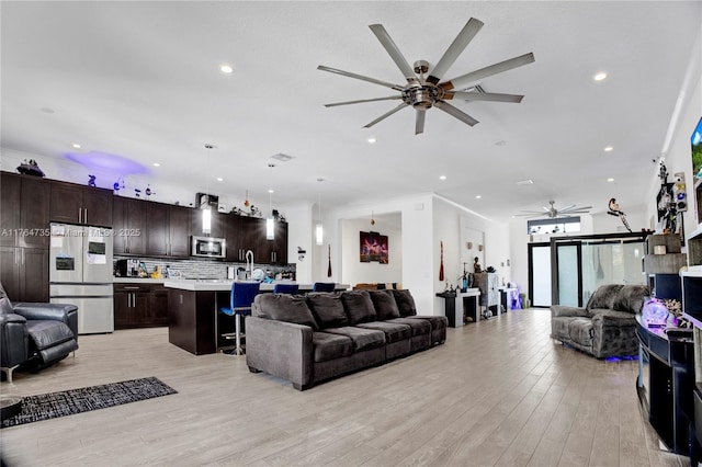 living room featuring recessed lighting, light wood-style flooring, and ceiling fan
