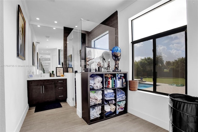 bathroom with recessed lighting, baseboards, wood finished floors, and vanity