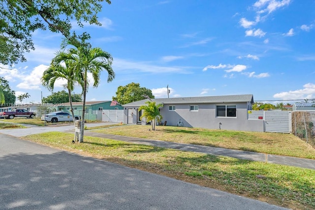 10341 SW 150th Ter, Miami, FL 33176 - ranch-style house featuring fence, a front yard, stucco siding, driveway, and a gate