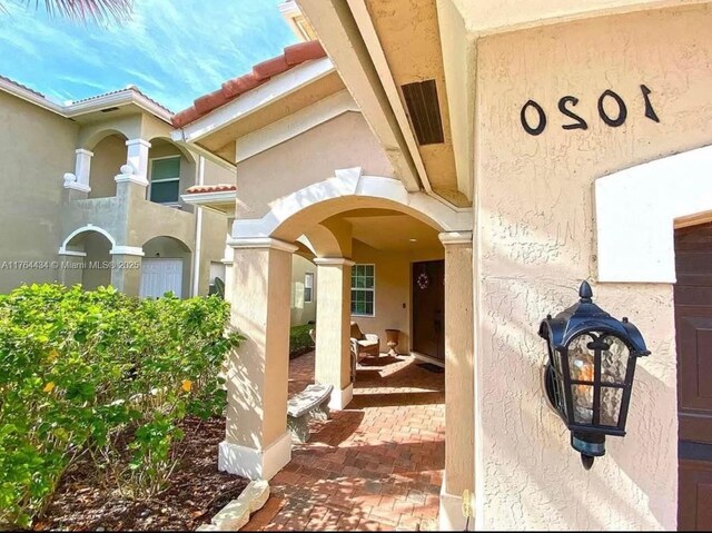1020 NW Leonardo Cir, Port St Lucie, FL 34986 - property entrance with stucco siding and a tiled roof