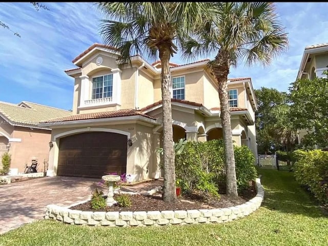 1020 NW Leonardo Cir, Port St Lucie, FL 34986 - mediterranean / spanish-style home featuring stucco siding, decorative driveway, an attached garage, and a tiled roof