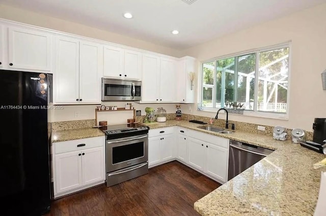 1020 NW Leonardo Cir, Port St Lucie, FL 34986 - kitchen featuring a sink, white cabinetry, stainless steel appliances, light stone countertops, and dark wood-style flooring