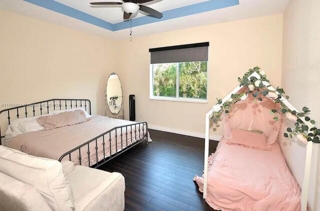1020 NW Leonardo Cir, Port St Lucie, FL 34986 - bedroom featuring baseboards, a raised ceiling, ceiling fan, and hardwood / wood-style flooring