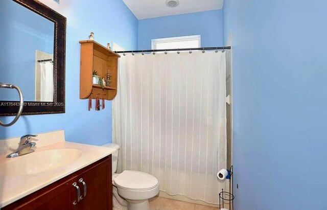 1020 NW Leonardo Cir, Port St Lucie, FL 34986 - full bathroom featuring vanity, tile patterned floors, toilet, and a shower with curtain