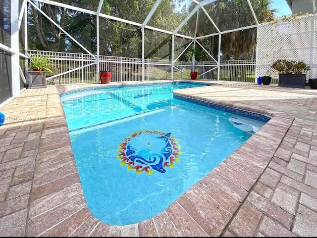 1020 NW Leonardo Cir, Port St Lucie, FL 34986 - view of pool featuring glass enclosure, a patio area, a fenced in pool, and fence