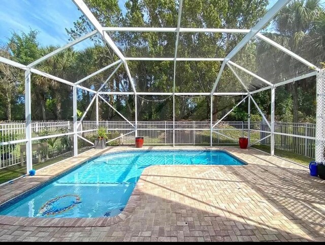 1020 NW Leonardo Cir, Port St Lucie, FL 34986 - view of pool featuring a fenced in pool, a patio, a fenced backyard, and glass enclosure