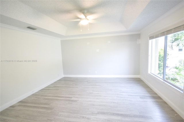 empty room featuring visible vents, a textured ceiling, a raised ceiling, and ceiling fan