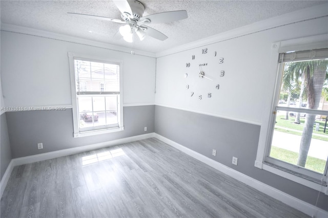unfurnished room featuring ceiling fan, a textured ceiling, baseboards, and wood finished floors