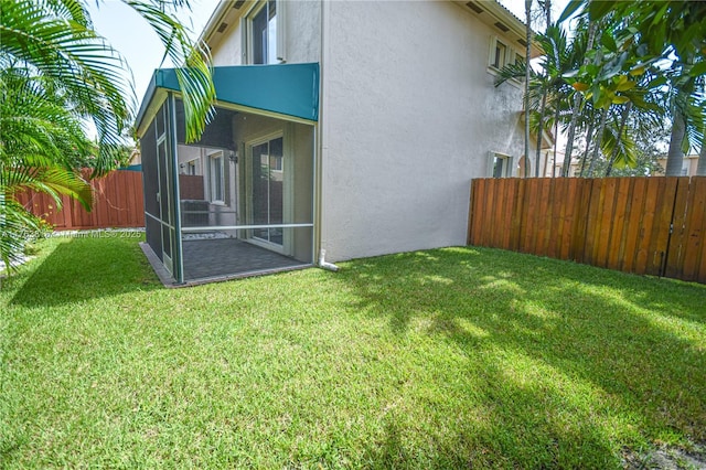 view of yard featuring a fenced backyard and a sunroom