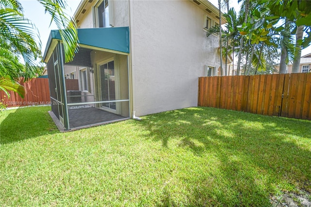 view of yard featuring a fenced backyard and a sunroom