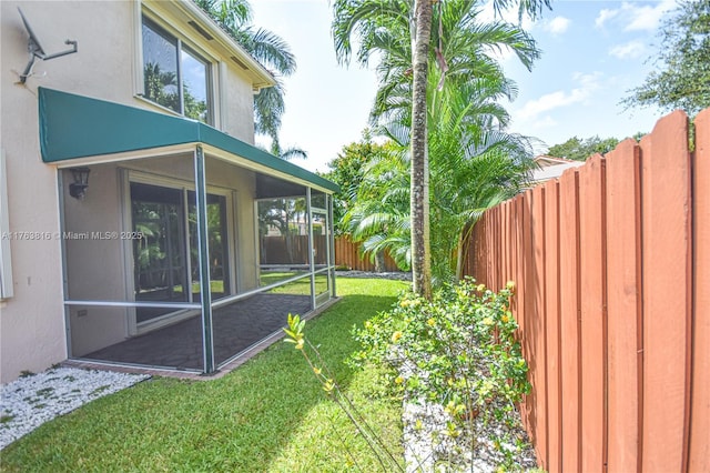 view of yard with a fenced backyard and a sunroom