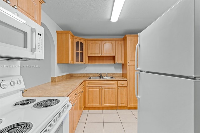 9952 SW 88th St Unit 9952, Miami, FL 33176 - kitchen with white appliances, light countertops, light tile patterned flooring, glass insert cabinets, and a textured ceiling