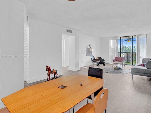 900 NE 195th St Unit 504, Miami, FL 33179 - dining area with baseboards, wood finished floors, visible vents, and expansive windows
