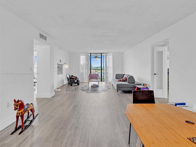 900 NE 195th St Unit 504, Miami, FL 33179 - living room with visible vents, baseboards, wood finished floors, and expansive windows