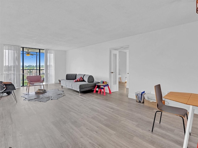 900 NE 195th St Unit 504, Miami, FL 33179 - living room with a wall of windows, wood finished floors, and a textured ceiling