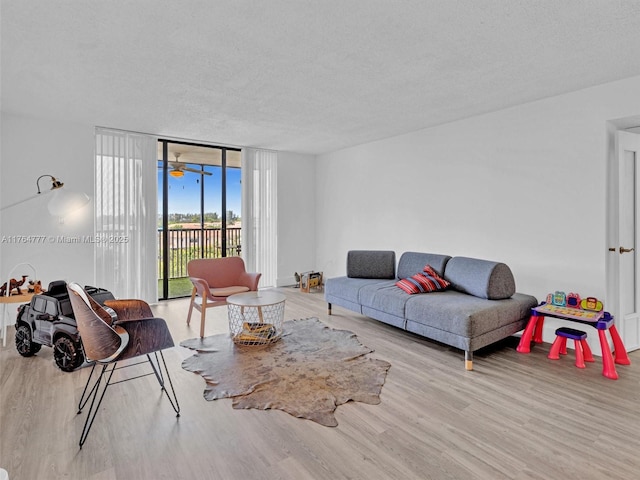 900 NE 195th St Unit 504, Miami, FL 33179 - living room featuring a wall of windows, wood finished floors, and a textured ceiling