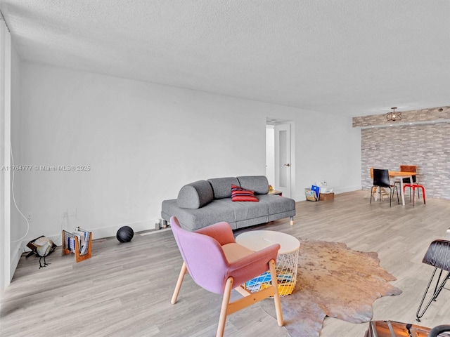 900 NE 195th St Unit 504, Miami, FL 33179 - living area featuring light wood-style floors, baseboards, and a textured ceiling