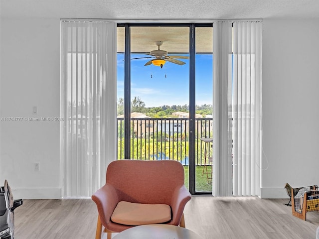 900 NE 195th St Unit 504, Miami, FL 33179 - sitting room with a wall of windows, a textured ceiling, wood finished floors, and a ceiling fan