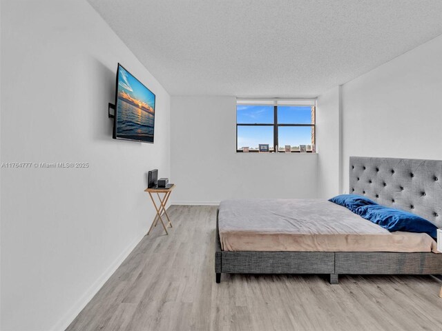 900 NE 195th St Unit 504, Miami, FL 33179 - bedroom featuring wood finished floors, baseboards, and a textured ceiling