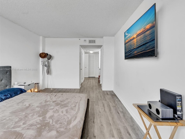 900 NE 195th St Unit 504, Miami, FL 33179 - bedroom featuring baseboards, wood finished floors, visible vents, and a textured ceiling