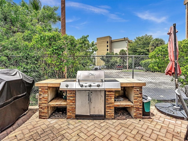 900 NE 195th St Unit 504, Miami, FL 33179 - view of patio with exterior kitchen and fence