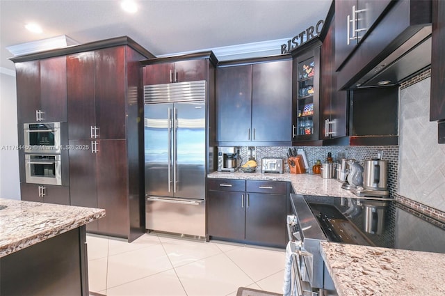 747 NE 193rd Ter, Miami, FL 33179 - kitchen featuring backsplash, appliances with stainless steel finishes, glass insert cabinets, and light stone countertops