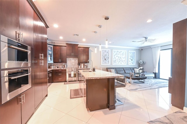 747 NE 193rd Ter, Miami, FL 33179 - kitchen featuring visible vents, backsplash, open floor plan, stainless steel double oven, and light tile patterned floors
