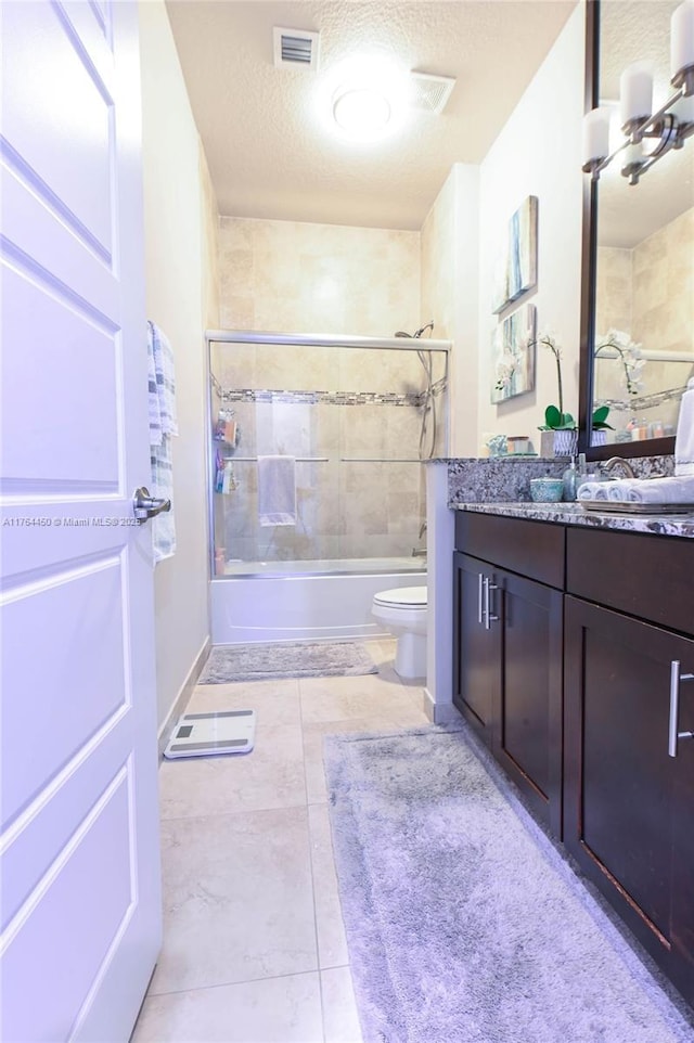 747 NE 193rd Ter, Miami, FL 33179 - full bath with vanity, visible vents, bath / shower combo with glass door, a textured ceiling, and toilet