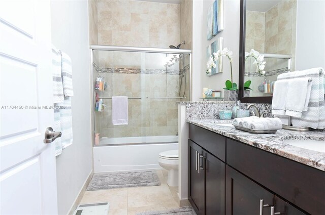 747 NE 193rd Ter, Miami, FL 33179 - bathroom featuring tile patterned floors, toilet, combined bath / shower with glass door, double vanity, and baseboards