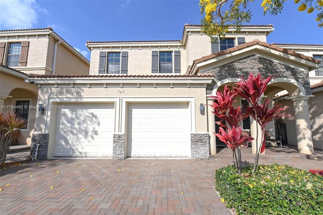 747 NE 193rd Ter, Miami, FL 33179 - view of front of home with a tiled roof, decorative driveway, stone siding, and stucco siding