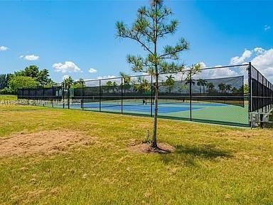 747 NE 193rd Ter, Miami, FL 33179 - view of sport court with a lawn and fence