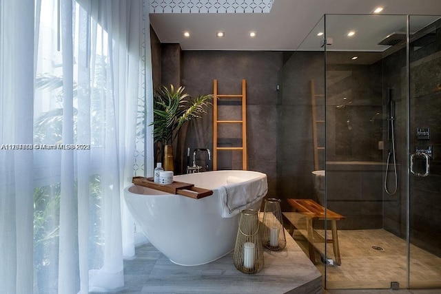 full bath featuring recessed lighting, a soaking tub, and a stall shower