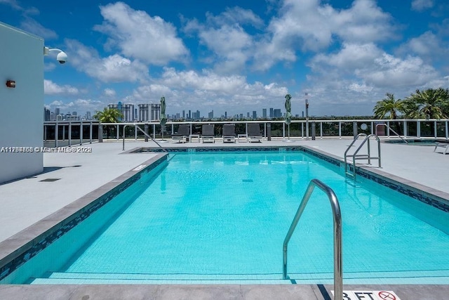 pool with a view of city and a patio area