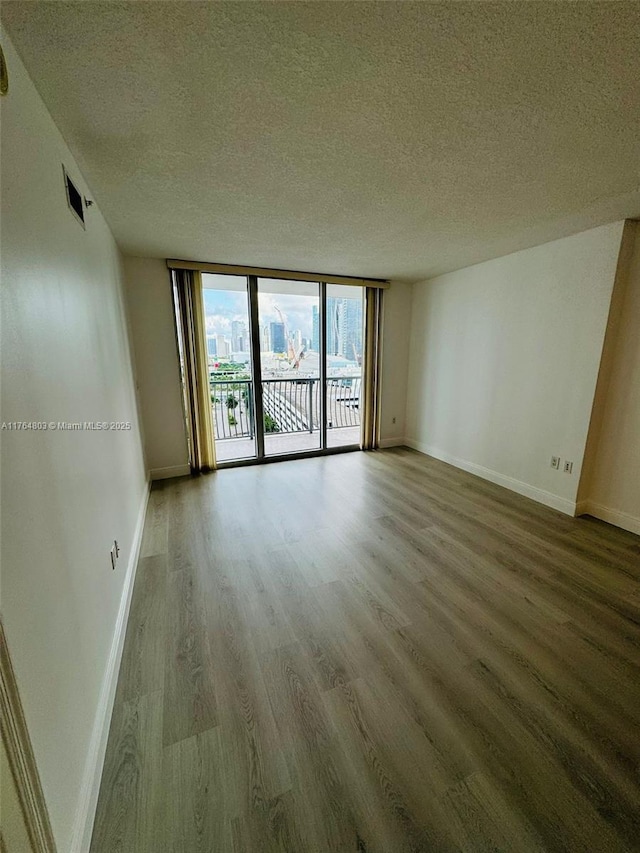 1750 N Bayshore Dr Unit 1606, Miami, FL 33132 - empty room with wood finished floors, a textured ceiling, baseboards, and expansive windows