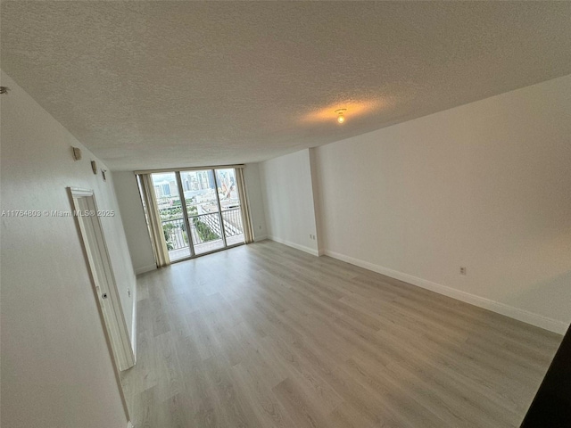 1750 N Bayshore Dr Unit 1606, Miami, FL 33132 - spare room with light wood finished floors, a textured ceiling, baseboards, and floor to ceiling windows