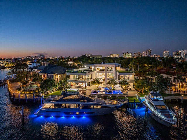 aerial view at dusk featuring a water view