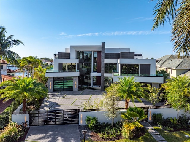 contemporary home with stucco siding, a fenced front yard, driveway, and a gate