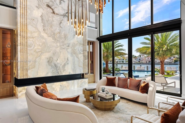 living area featuring floor to ceiling windows and a towering ceiling