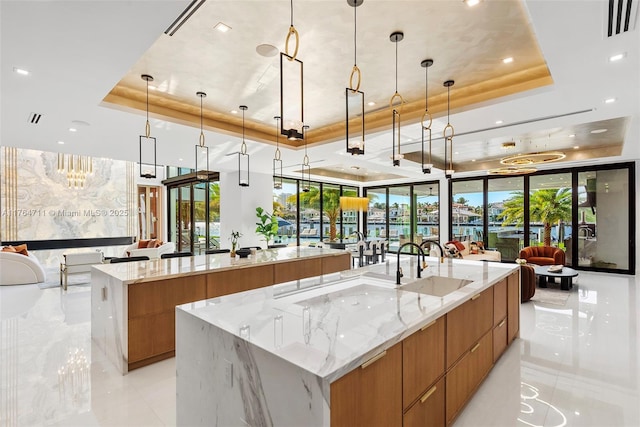 kitchen featuring a tray ceiling, a large island, modern cabinets, and open floor plan