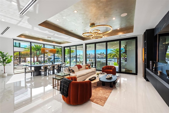 living area with visible vents, floor to ceiling windows, and a tray ceiling