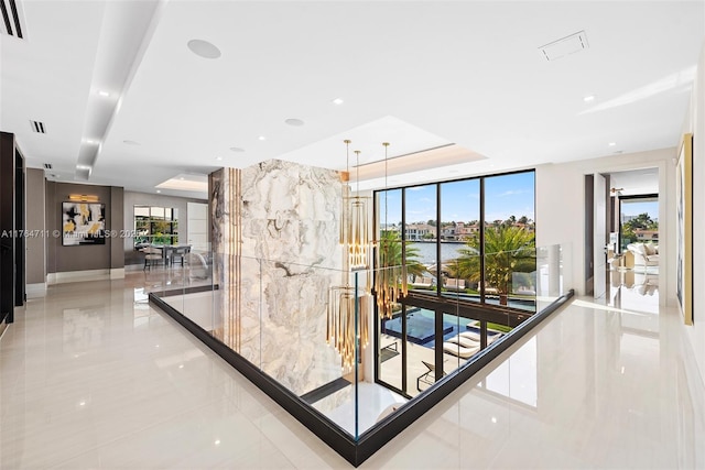 wine cellar featuring a raised ceiling and floor to ceiling windows