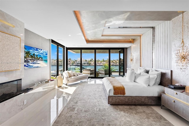 bedroom featuring tile patterned floors, a glass covered fireplace, floor to ceiling windows, and access to exterior