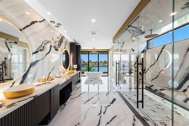 bathroom with double vanity, a marble finish shower, a soaking tub, and marble finish floor