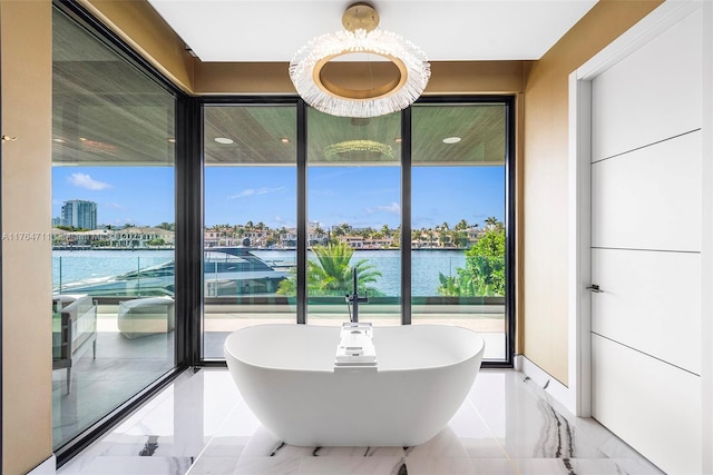 dining area featuring a water view and marble finish floor