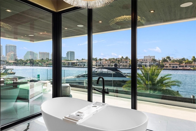 view of patio / terrace with a city view, a balcony, and a water view