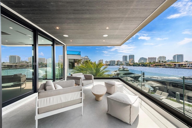 balcony with a city view, an outdoor living space, and a water view