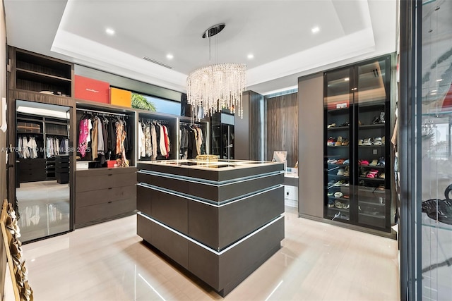 spacious closet featuring an inviting chandelier, visible vents, and a tray ceiling