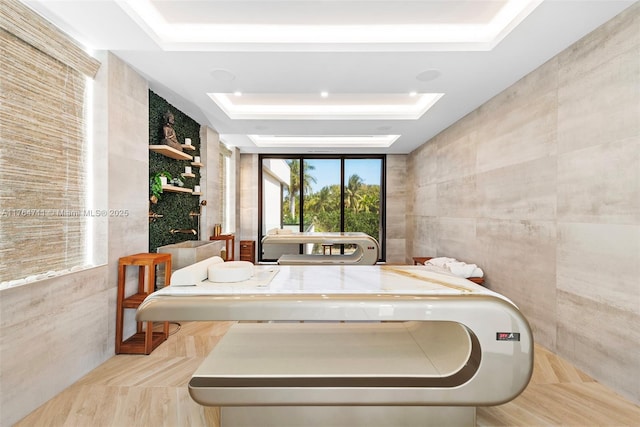 bathroom with tile walls and a tray ceiling