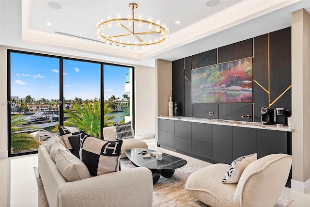 living room featuring an inviting chandelier and a tray ceiling